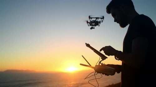 Sunset, technology and a man flying a drone over the ocean in nature for video footage during