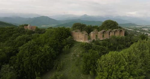 Historical medieval palace ruins on wooded hill in Alvani, Georgia.
