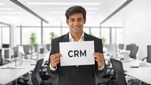 Happy Indian manager holding CRM banner