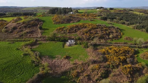 Drone Flight Over a Small House Standing Alone in a Field in the Irish Village