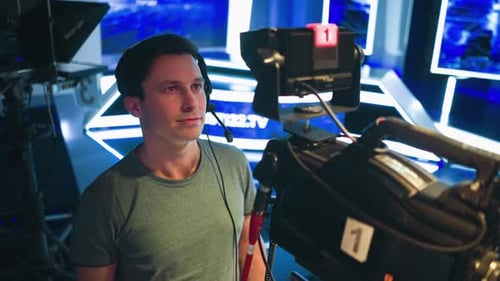 Cameraman Wearing Headset Operating Studio Camera During Live Television Broadcast
