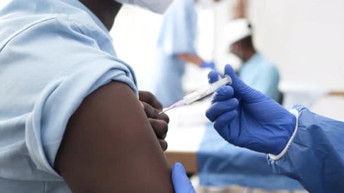 Médico profesional que inyecta la vacuna contra el coronavirus a un paciente masculino en el hospital. Medium shot