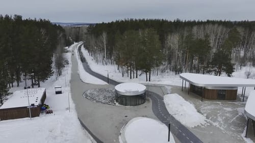 City Park with Cafes and Parked Vehicle on Winter Day