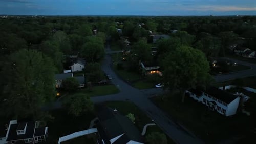 Two story homes with warm Lighting windows in quiet suburb district of american town during blue hou