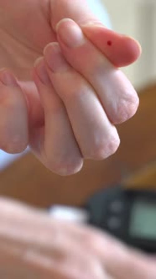 Diabetic Patient Measuring Blood Glucose Level with a Glucometer