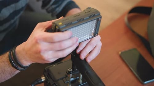 Studio Guy Adjusting Light Panel While Setting Up Video Equipment