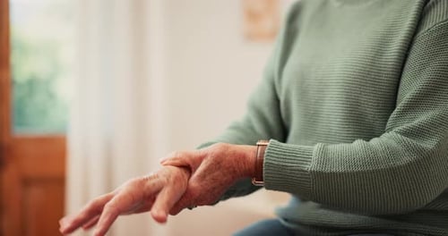 Senior person, hands and pain of wrist from parkinson, injury or orthopedic care at home