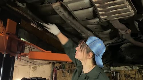 Young Female Mechanic Performing Car Bodywork at Service Station