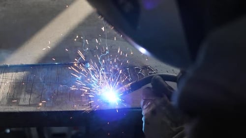 Welder on the table welds a set of metal parts. Welder working. Working with metal