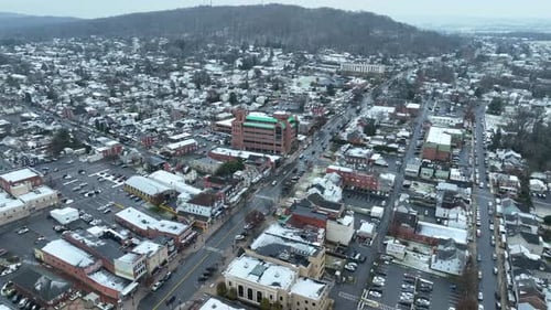 Aerial establishing shot of American suburb covered in snow. Small town USA.