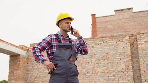 Construction Worker in Uniform and Safety Equipment Have Job on Building