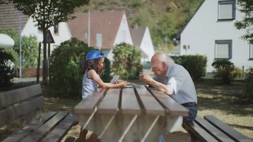 The grandfather is serious about teaching his grandson to play cards, dolly shot