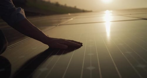 Cinematic shot of maintenance assistance technical worker in uniform is cleaning photovoltaic sola