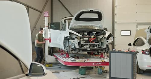 Mechanic Working on Car Repair and Body Alignment in a Clean Modern Workshop