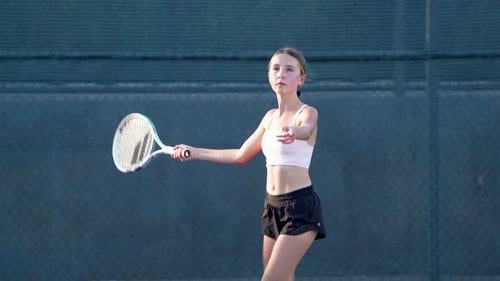 A teenager practicing tennis on a summer afternoon.