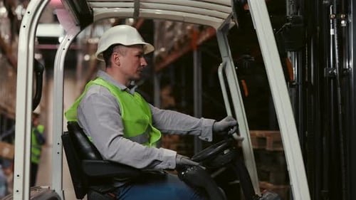 Male Warehouse Worker Operating Forklift
