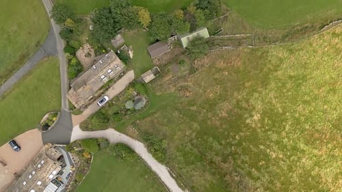 Imagens aéreas de uma vila rural de Yorkshire com uma chaminé de moinho. Filmado em Leeming acima de Oxenhope e
