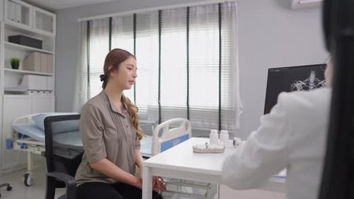 Una joven asiática visita y consulta un problema de salud con un médico en el hospital.
