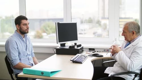 Médico sénior habla sobre un problema de salud con un joven paciente hispano en el hospital