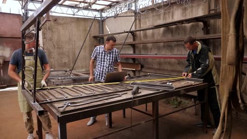 A Group of Blacksmiths Works in a Forge They Weld Rods with a Welding Machine