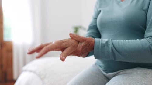Hand, wrist pain or arthritis with a senior on the bed in a home for recovery from injury closeup