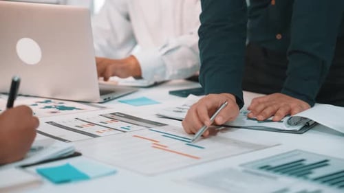 Business professionals collaborating on project analysis using charts, reports, and data for strateg