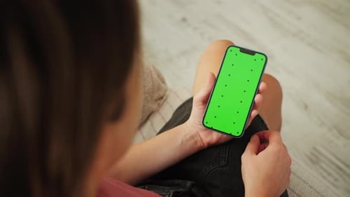 Close Up of Female Using Smartphone with Green Screen at Home in Living Room