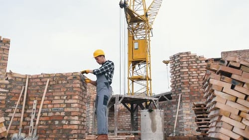 Construction worker in uniform and safety equipment have job on building