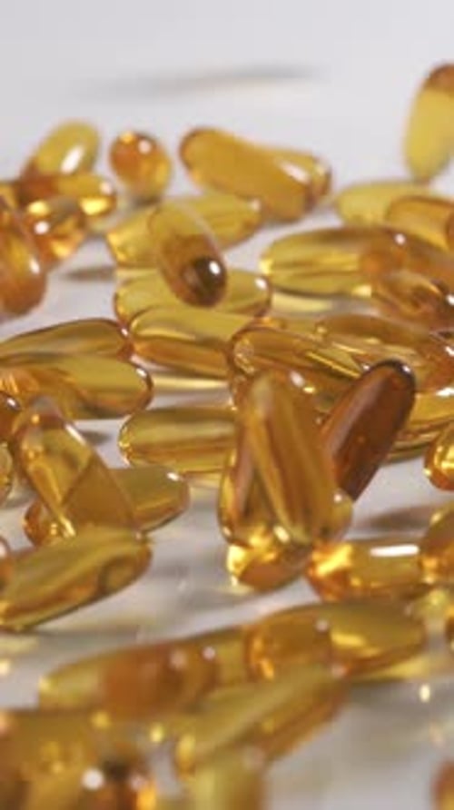 Vitamins and supplements fall in slow motion. Vertical Video.