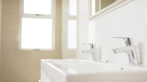 Nahaufnahme von Waschbecken und Chromarmaturen im Badezimmer, Zeitlupe