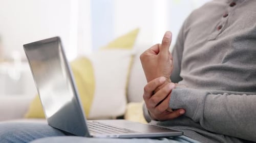 Closeup man, wrist pain and injury at laptop from osteoporosis, orthopedic and typing