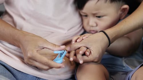 Mother Clipping Fingernails Of Her Son