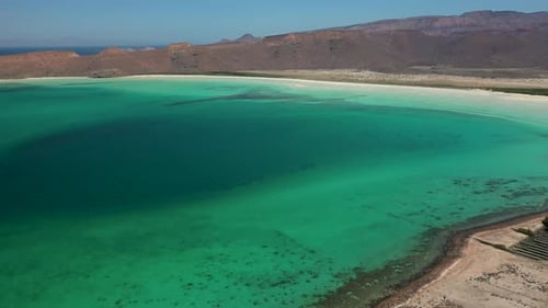 Cinematic wide drone shot of Balandra Beach, view turquoise waters, white-sand beaches, and mountain