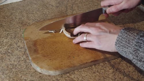 Couper un champignon sur une planche à découper en bois. Le champignon est à l'envers
