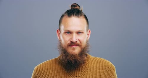 A man showing the peace sign against a grey background