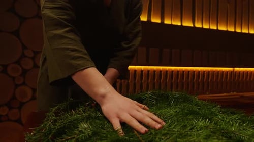 Mulher atendente de banho preparando a sauna a vapor no centro de spa Vista de perto da vassoura de abeto nas mãos