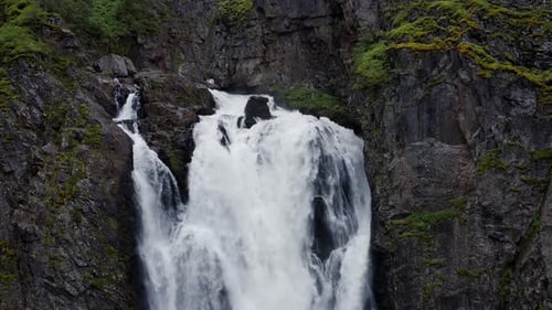 Voringfossen Waterfall and Cliffs with Green Trees in Norway at Sunny Summer Day