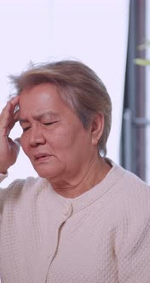 Anciana asiática con cefalea migrañosa. Mujer mayor que sufre de dolor de cabeza.