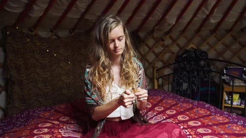 Mulher espiritual ecologicamente consciente na cama, iluminando incenso, palo santo. Xamanismo e espiritualidade, oeste