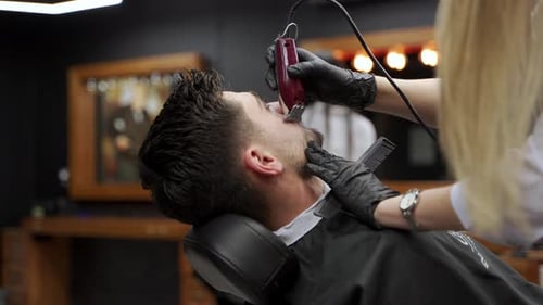 Professional Barber Gives Stylish Haircut to Man in Salon Expert Hairdresser Uses Scissors Comb