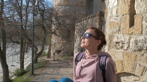 Una turista descansa cerca del castillo