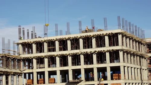 Construction workers in uniform installing and fabricating ground beam timber form works at the cons