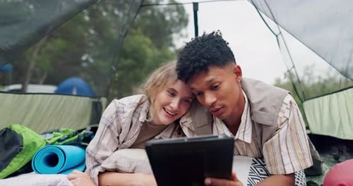 Happy couple, watching and camping with tablet in tent on vacation, holiday