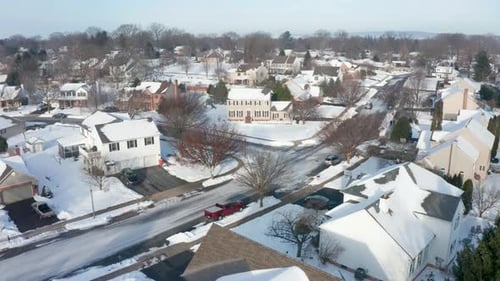 Neighborhood community development. Aerial establishing shot of winter scene. Snow covers homes and