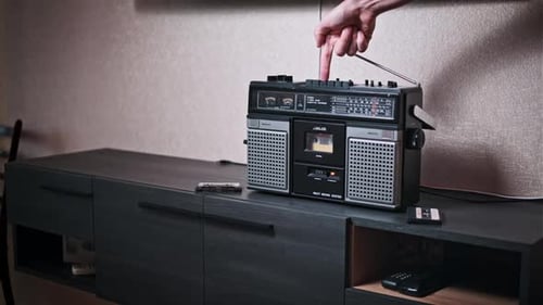 Vintage Boombox Pressing Play and Stop Buttons