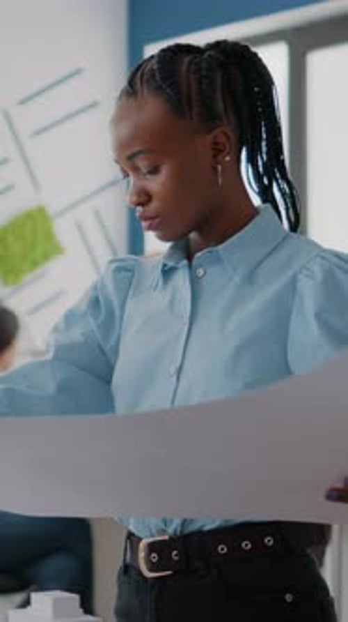 Vertical Video Woman Architect Analyzing Building Model and Blueprints Plans for Project Development