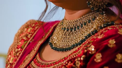 The Bride is Dressed in Traditional Red Indian Clothes with Beautiful Neckless on Her Neck Elements