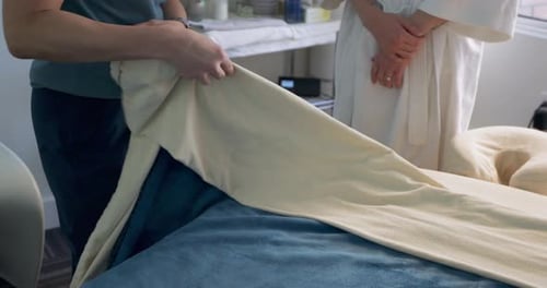 Massagista explicando a cama de tratamento de massagem