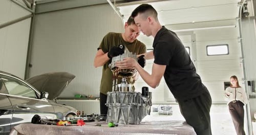 Mechanics Repairing An Electric Car Engine In A Service Garage
