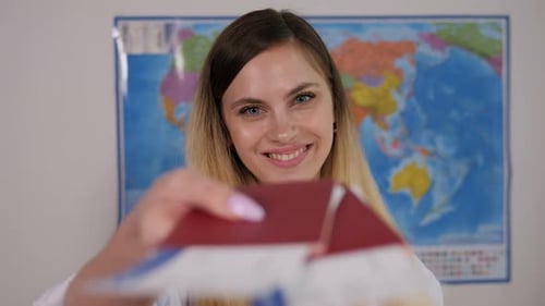A Woman of a Travel Agent in a Travel Agency with Passports and Tickets